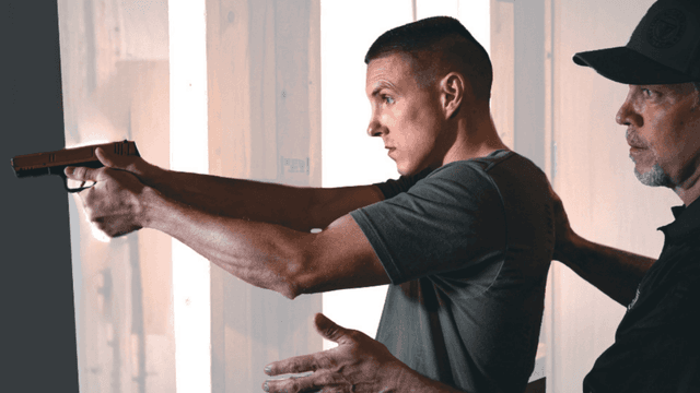 United Defense Tactical instructor guiding a participant in firearms training